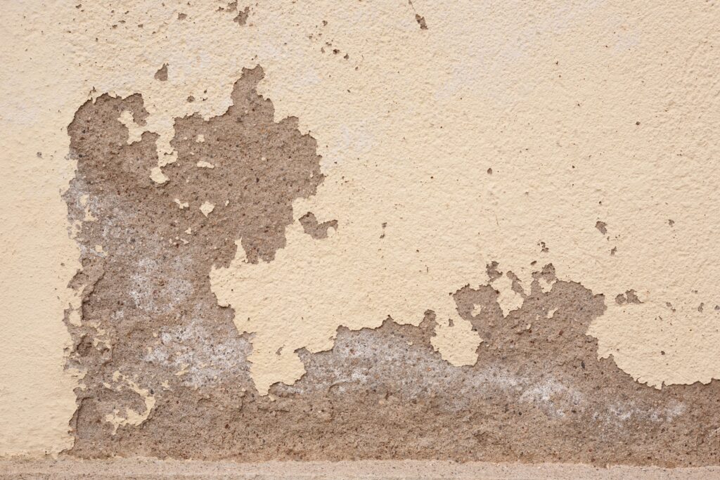 Old wall with cracked plaster showing rough textures, ideal for backgrounds.