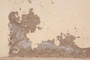 Old wall with cracked plaster showing rough textures, ideal for backgrounds.